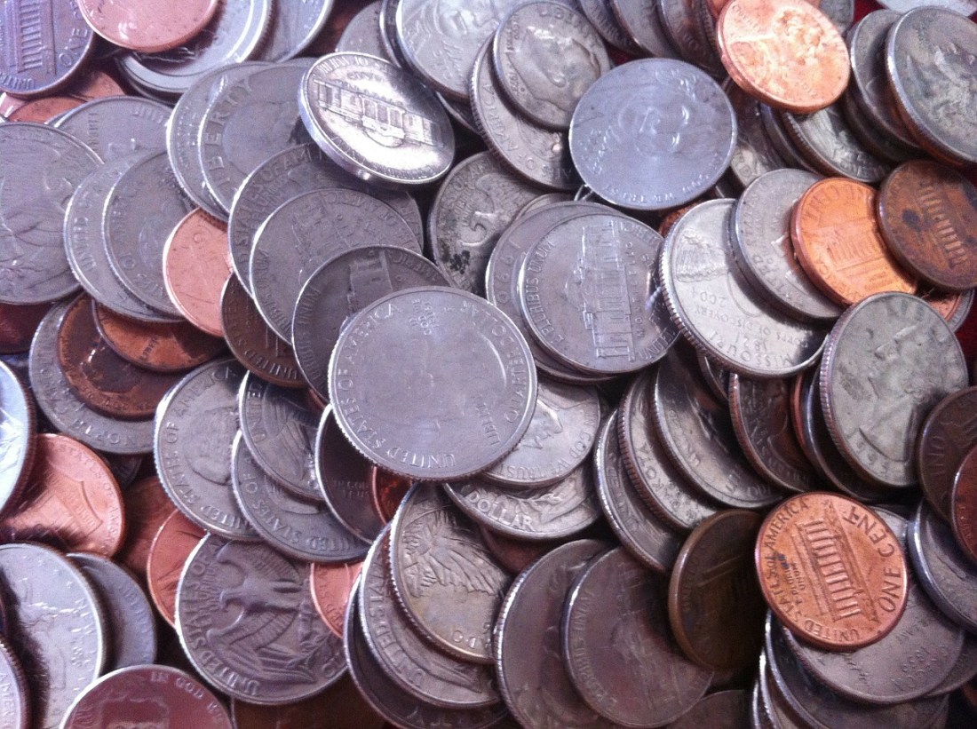 Pile of gold and silver coins representing the escalating license cost of Oracle RAC